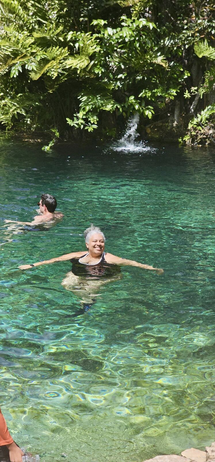 Alicia Minter swimming in a turquoise natural pool